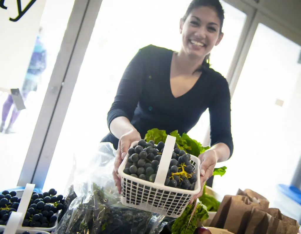 A volunteer sells fruits at one of the market's three booths (photo by Chris Parent)