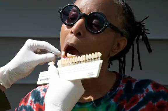 Dental technician Alison Tuton assessing the colour contrast of the author’s teeth before crafting a custom dental implant. Photo by Joanne Bealy