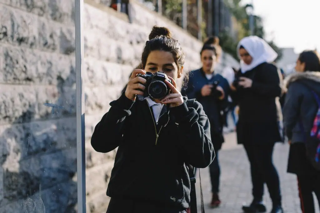 A girl, part of a group of students taking photos for a class as I walked down their school's street. At-Tur, East Jerusalem.
