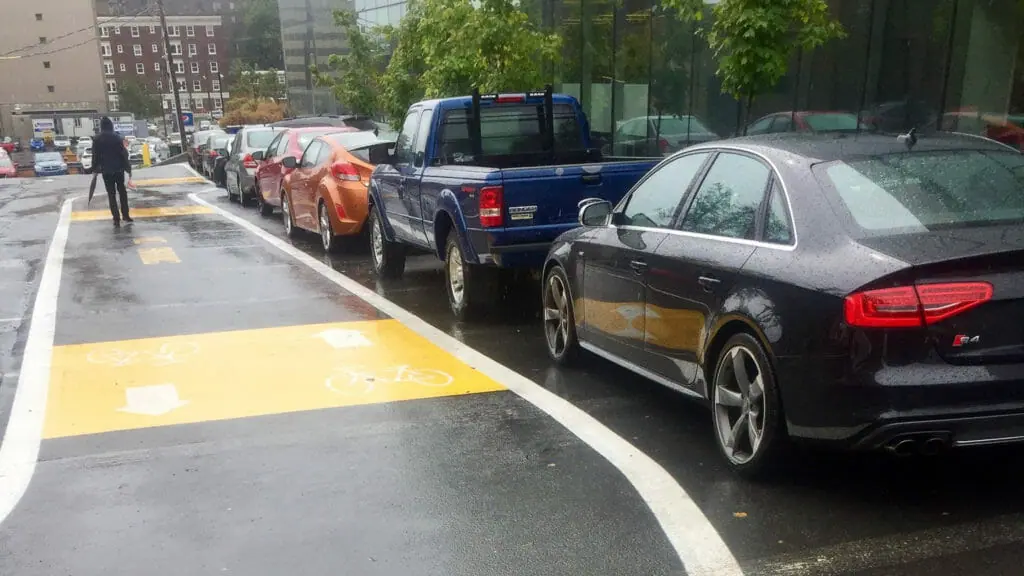 A bikelane with cars parked beside it.