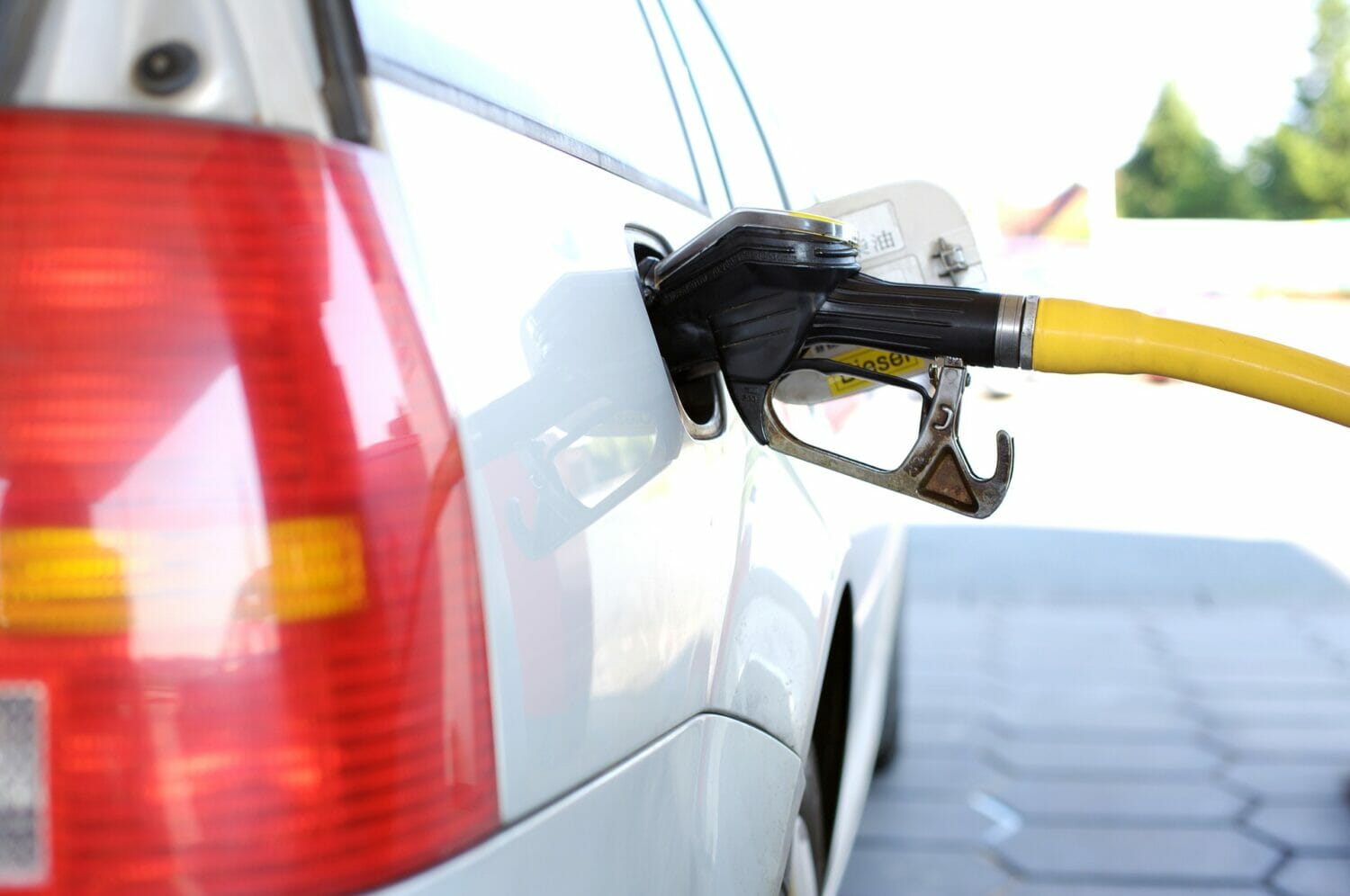 In this image: a car being pumped with gas.