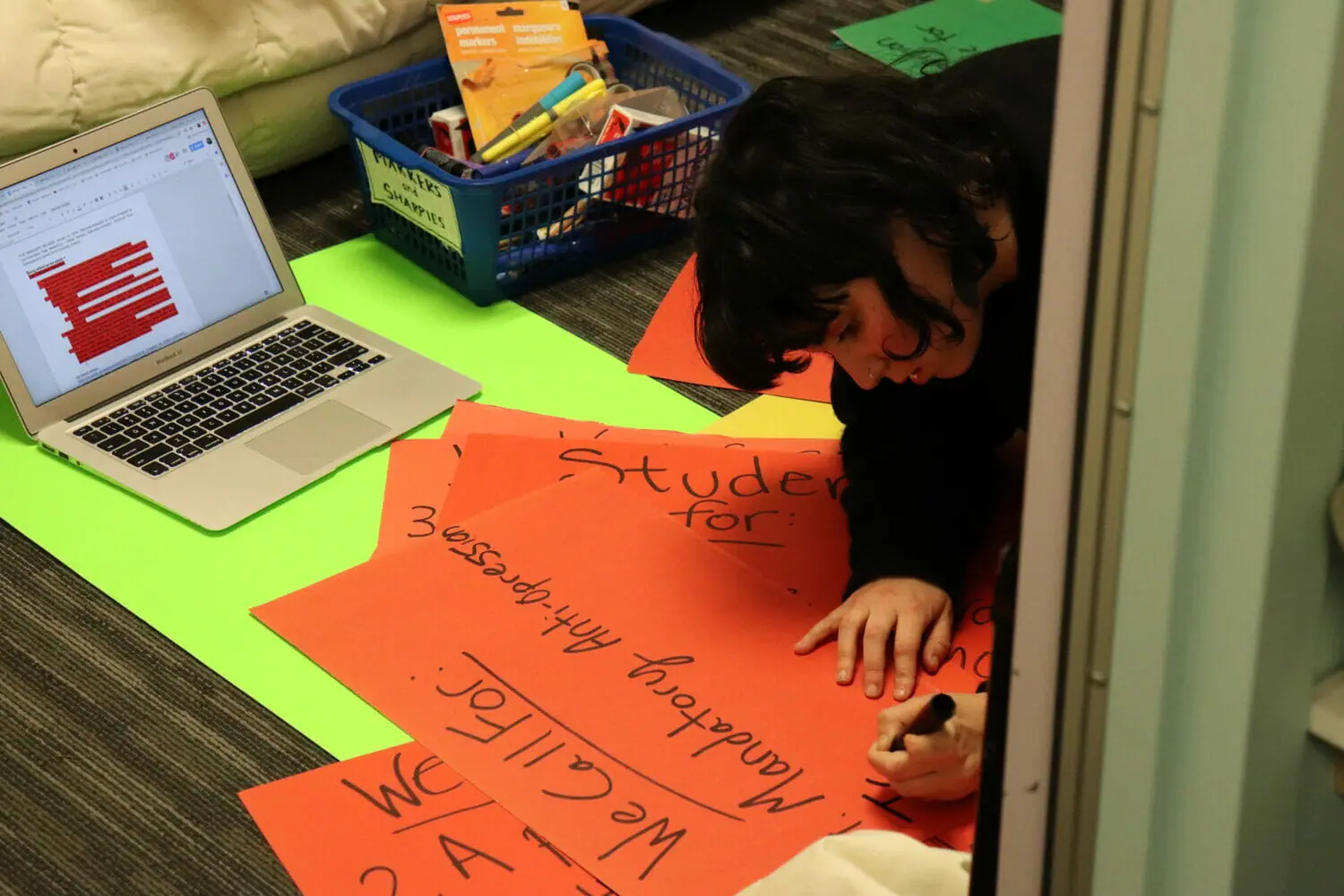 In this image: University of Kings College student, Pheobe Lamb, makes signs at the NSPPIRG office before the protest.
