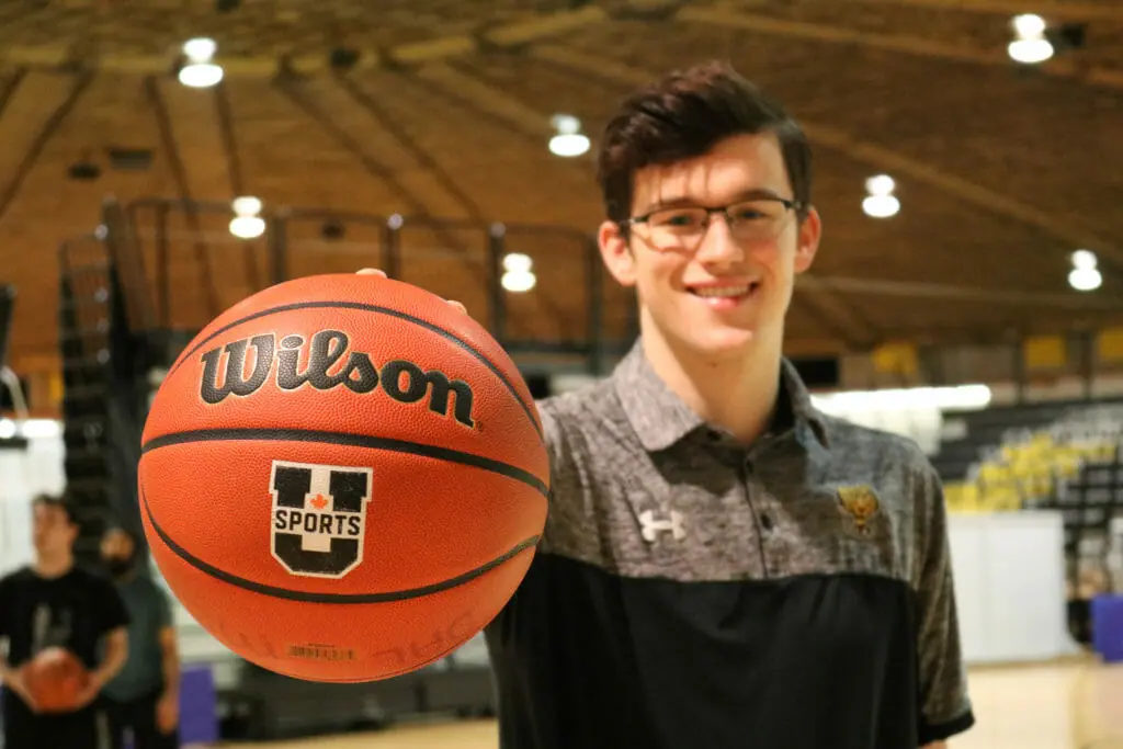 In this image: Sven Stammberger holds a basketball up to the camera.