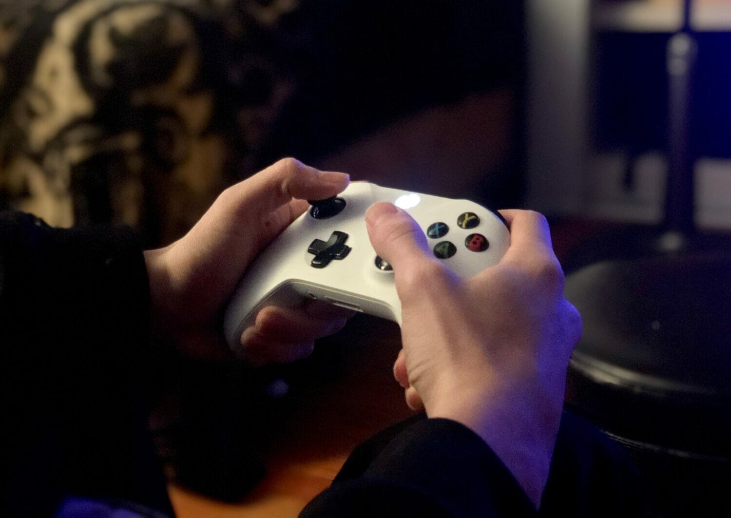 In this image: hands holding a white Xbox controller.