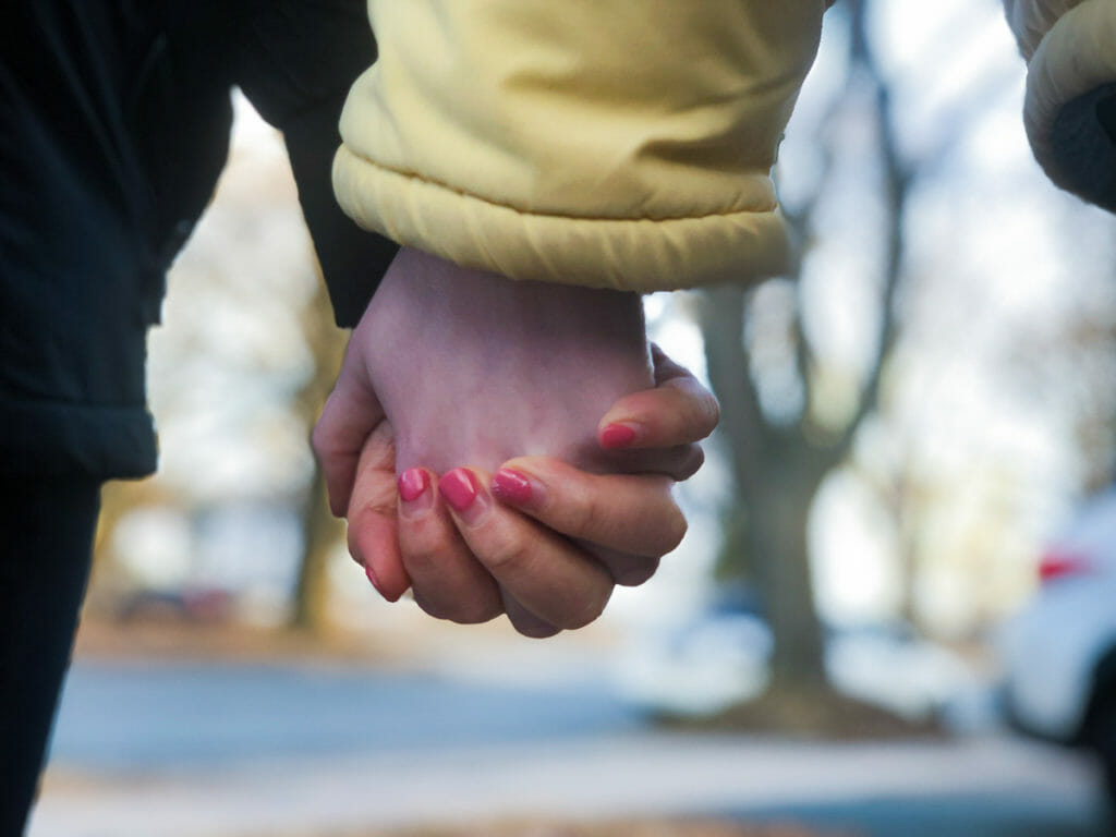 In this image: Close-up of holding hands.