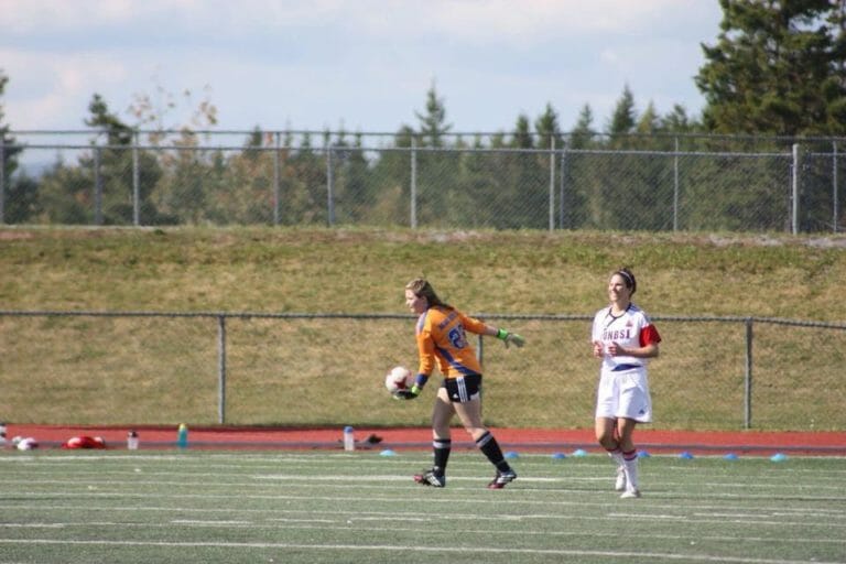In this image: Jessica Briand prepares to kick a soccer ball.