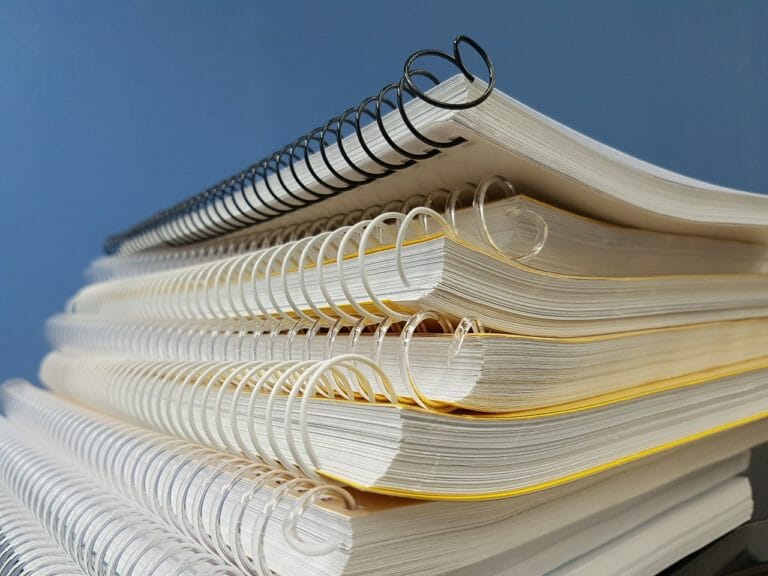In this image: a stack of wire-bound notebooks.