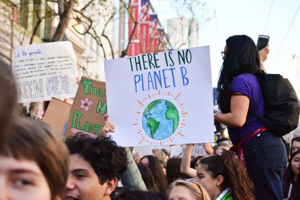 In this image: A rally with a sign saying "there is no planet B."