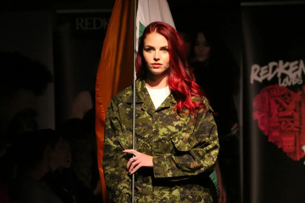 In this image: A model wears a camoflauge outfit.
