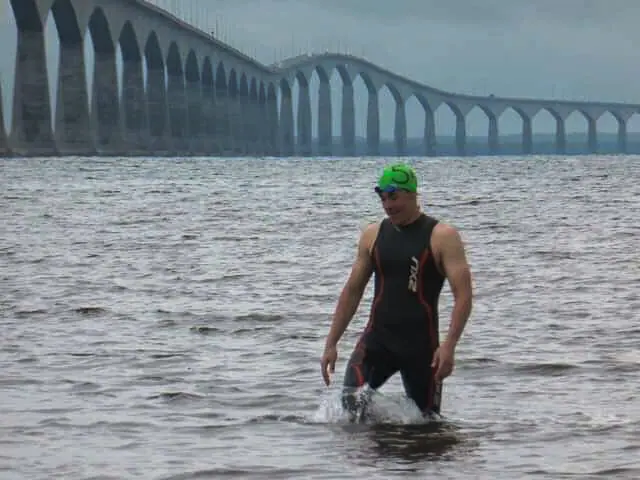 In this image: Tyler Immel-Herron in the shallow part of the Northumberland Strait with the Confederation Bridge in the background.
