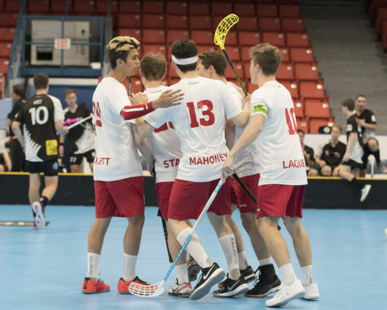 In this image: Team Canada from Men's World Floorball Championships huddles together.