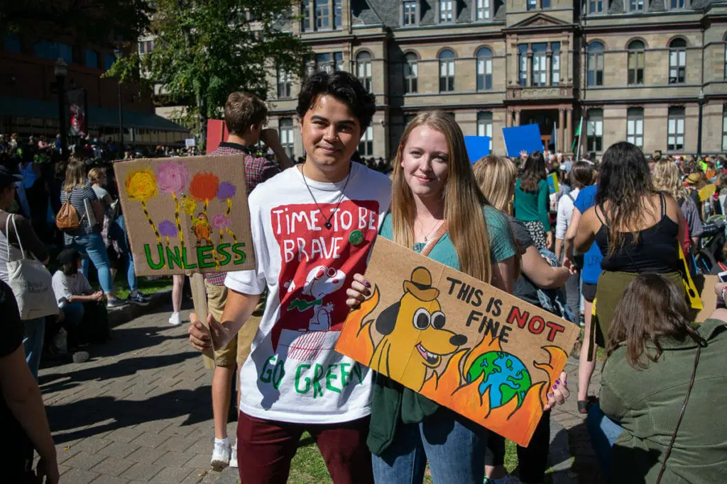 In this image: Two students pose with their signs.