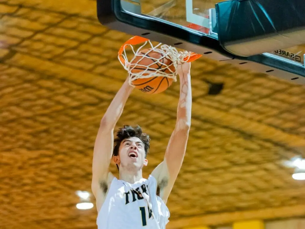 In this image: Sascha Kappos goes to dunk the basketball in a game.