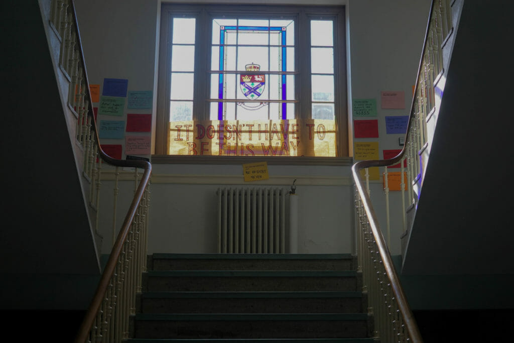In this image: A staircase with Post-It notes about tuition.