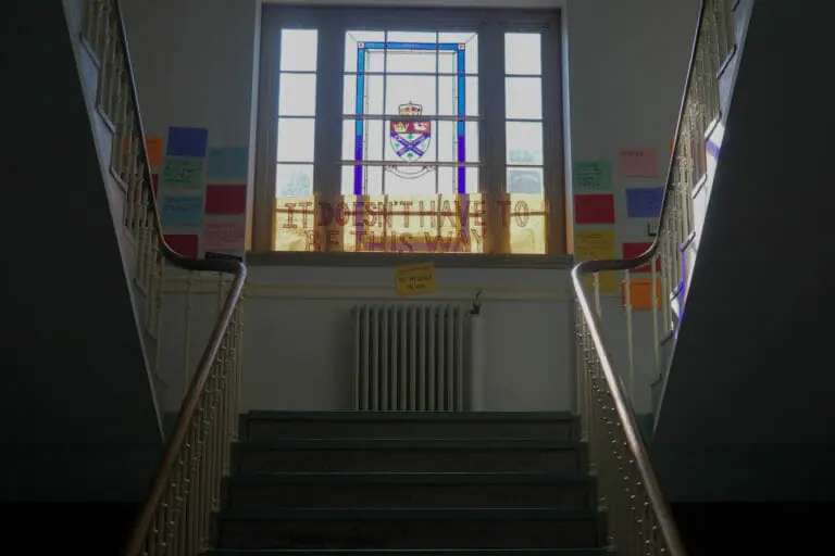 In this image: A staircase with Post-It notes about tuition.