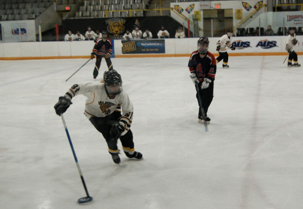 In this image: A Dalhousie University ringette player skates with the ring.