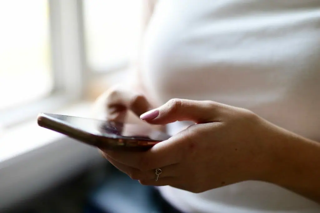 In this image: A person using a cellphone.