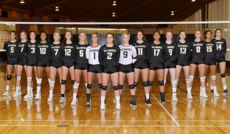 In this image: Dalhousie University's women's volleyball team pose in a "V" shape.