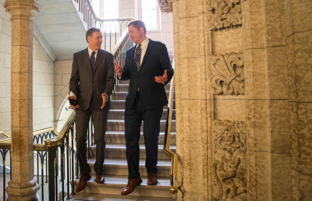 In this image: Maxime Bernier and Andrew Scheer walk down a staircase at Parliament Hill.