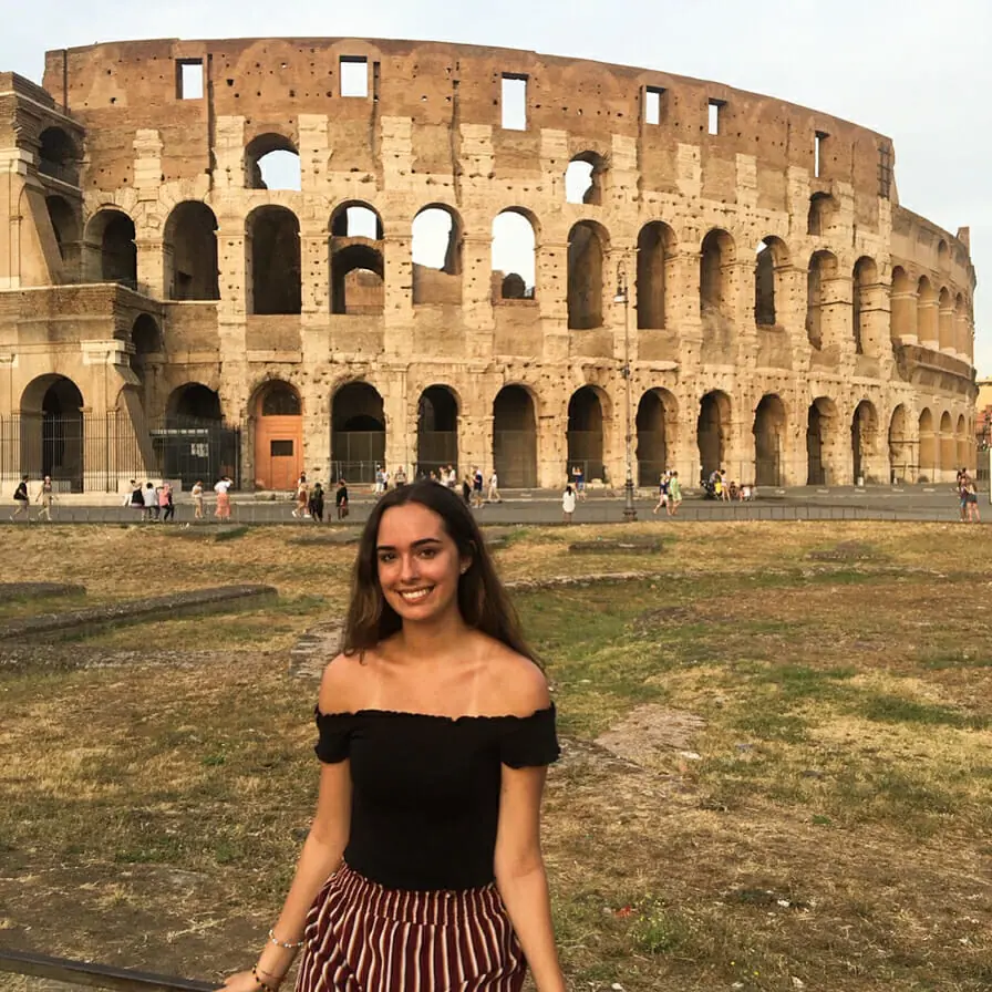 In this image: Olivia Ward poses in front of the Colesseum in Rome.