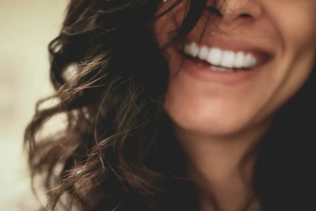 In this image: A woman laughs.