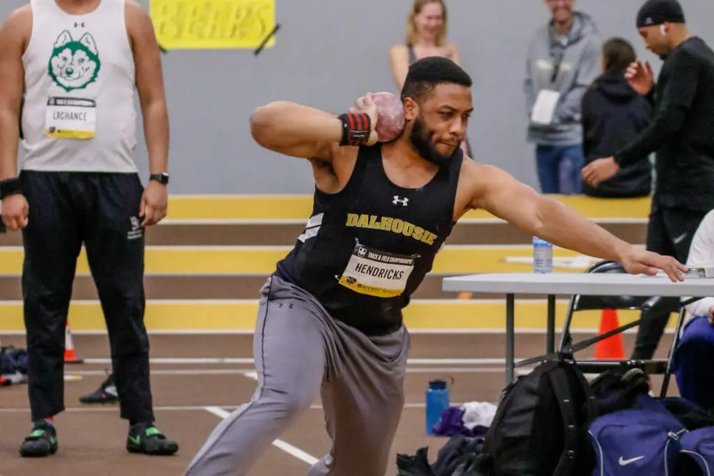 In this image: Andre Hendricks preparing to throw a shot put.