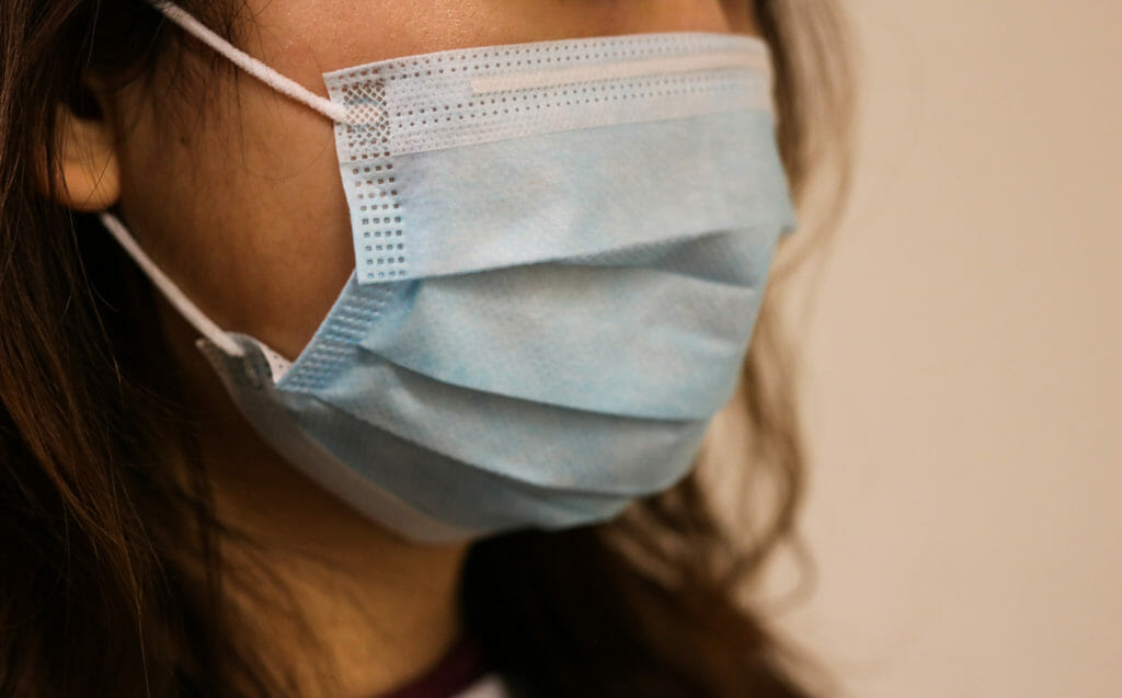 In this image: A person wearing a medical mask.