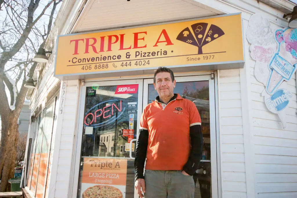 In this image: John Amyoony stands in front of Triple A.