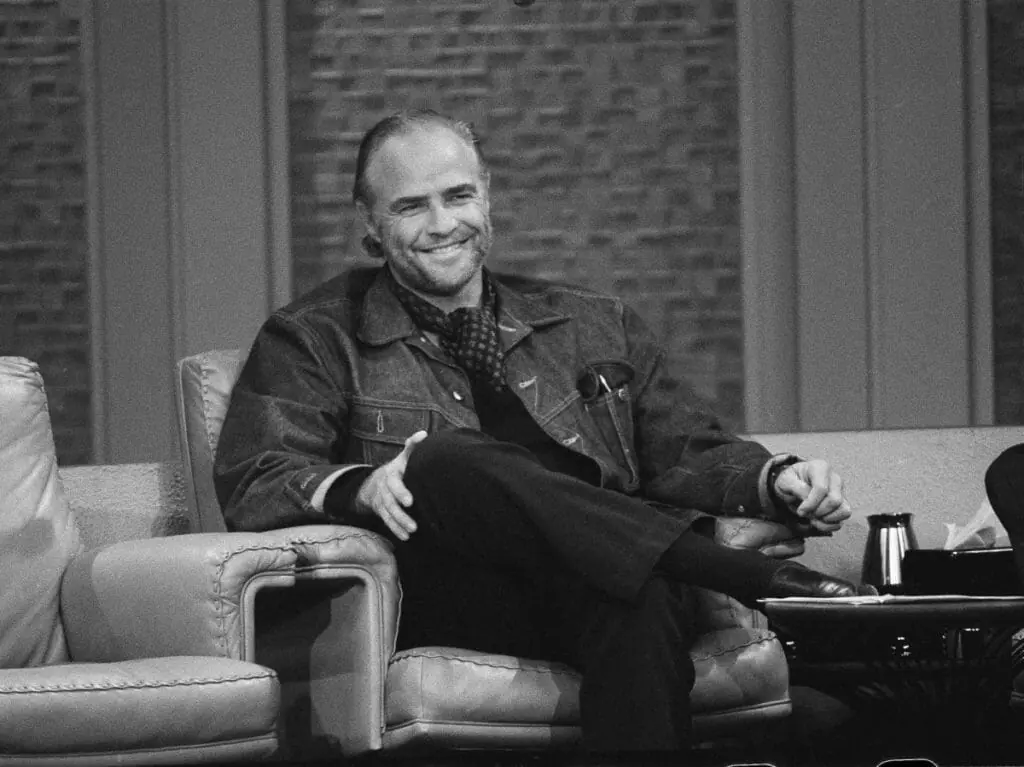 In this image: Marlon Brando sits in a chair on The Dick Cavett Show in 1973.