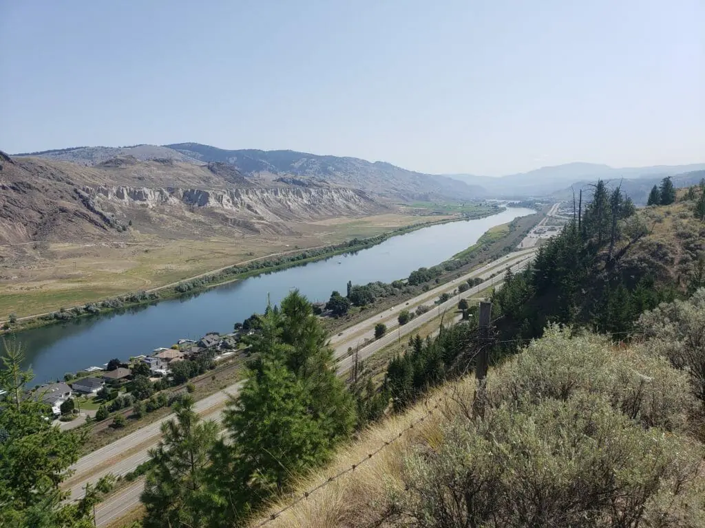In this image: Looking over a highway, small community and river.