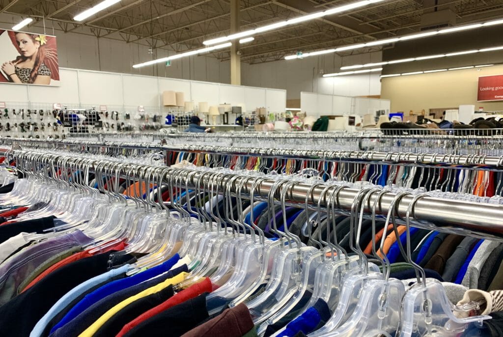 In this image: Racks of clothes at a thrift store.