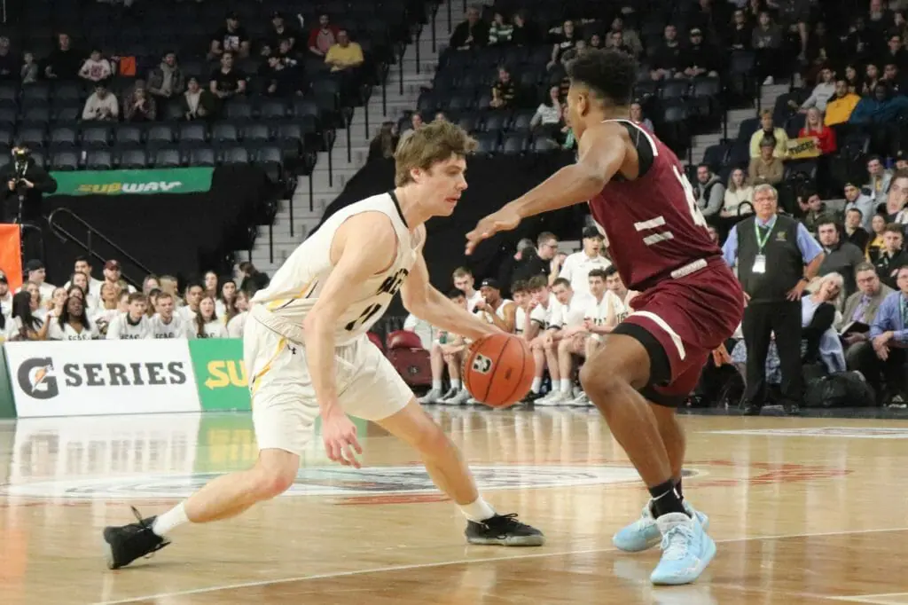In this image: A Dalhousie Tiger dribbles a basketball against a Saint Mary's Husky.