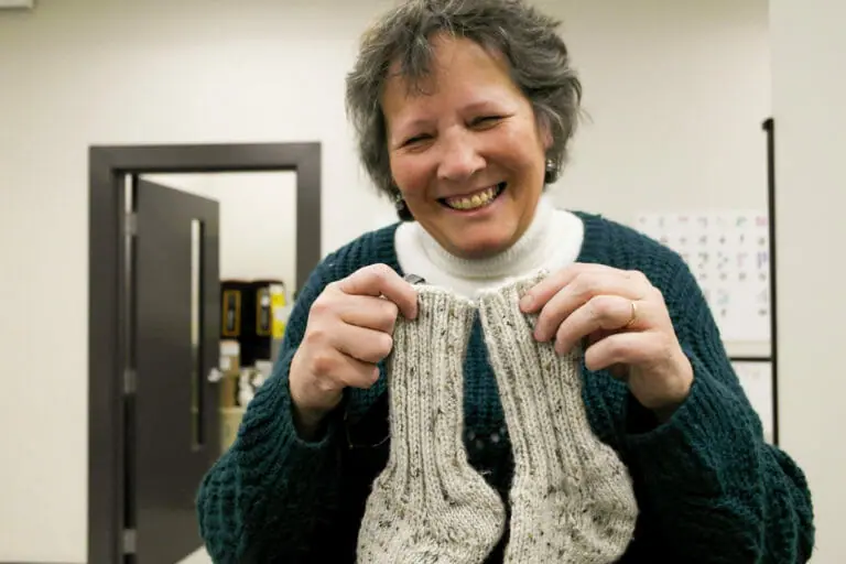 In this image: Irene Swain holds a pair of knitted socks.