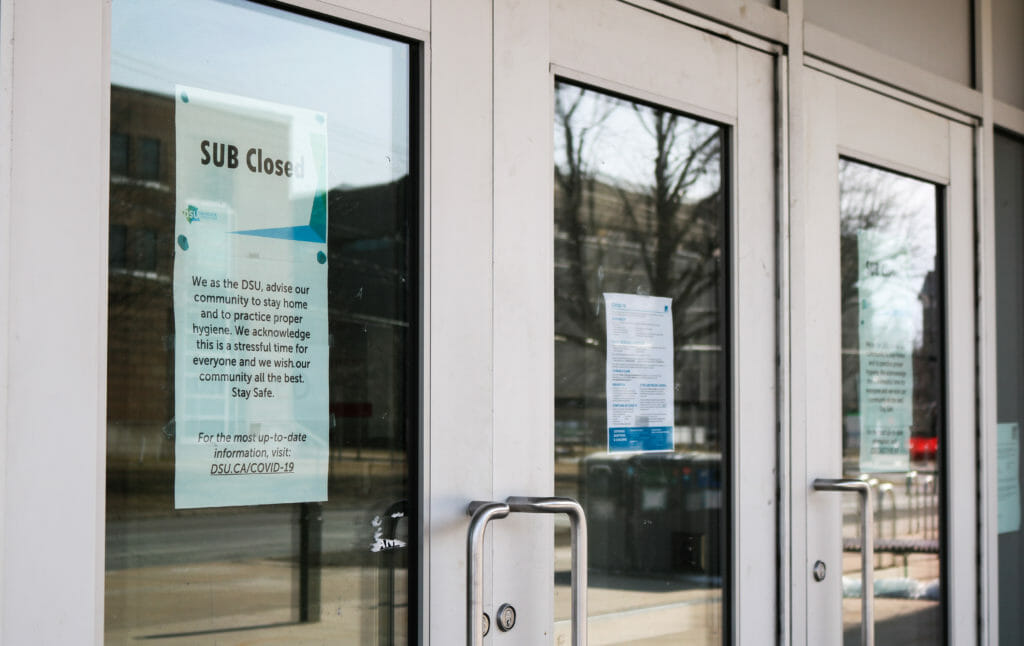 In this image: Signs posted on Dalhousie University's Student Union Building saying it's closed due to COVID-19.