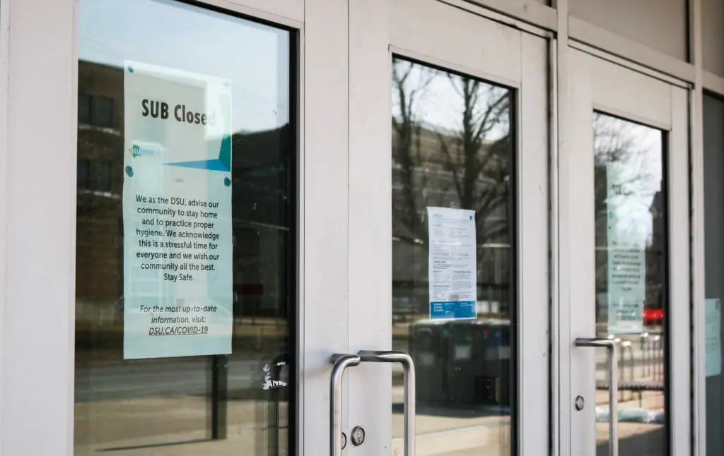 In this image: Signs posted on Dalhousie University's Student Union Building saying it's closed due to COVID-19.