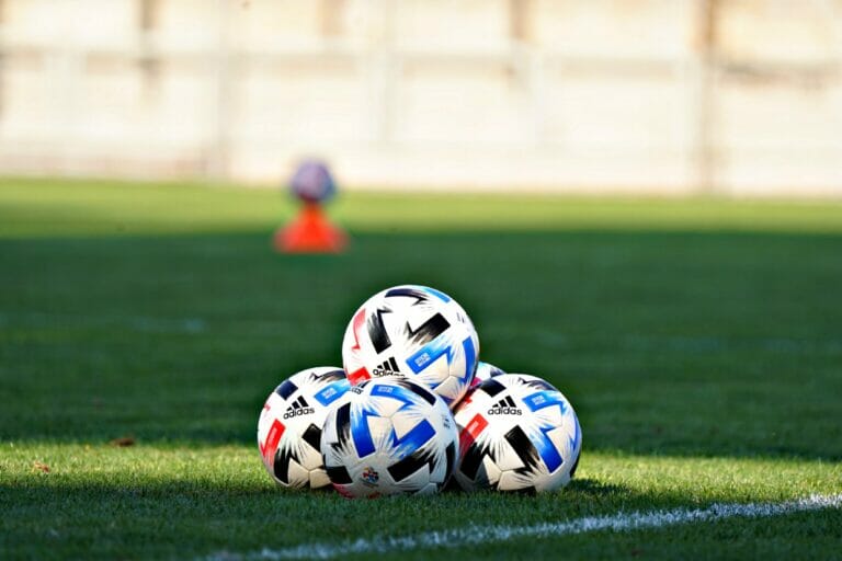 In this image: soccer balls on field