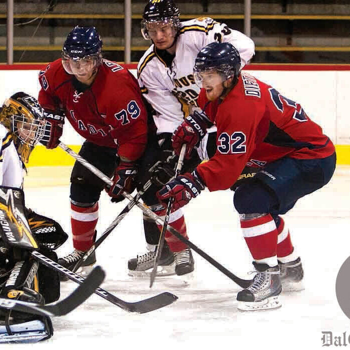 Acadia’s Jacob Dietrich tries to jam the puck under Tigers goalie Bobby Nadeau. Photo by Martina Marien