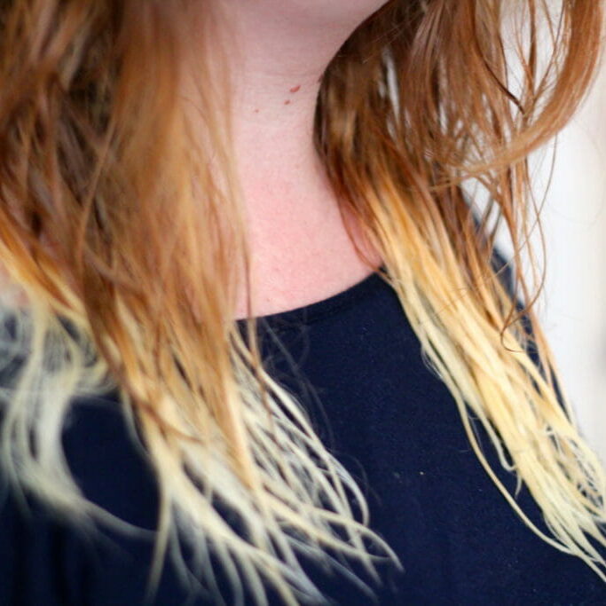 In this image: A girl's bleached hair.