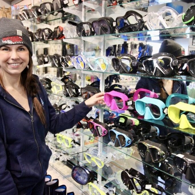 April Weickert adjusting the merchandise at her family owned Scuba store, Torpedo Rays Scuba Adventures. Image credit: Hannah Sangster