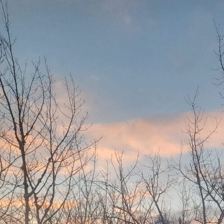 A photo of a blue sky at sunset with pink-coloured clouds.