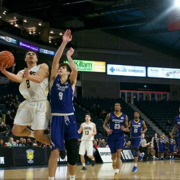Jordan Brathwaite goes for a layup while Nikola Urosevic guards him at the bronze medal game of the 2019 men's Final 8 at the Scotiabank centre. 