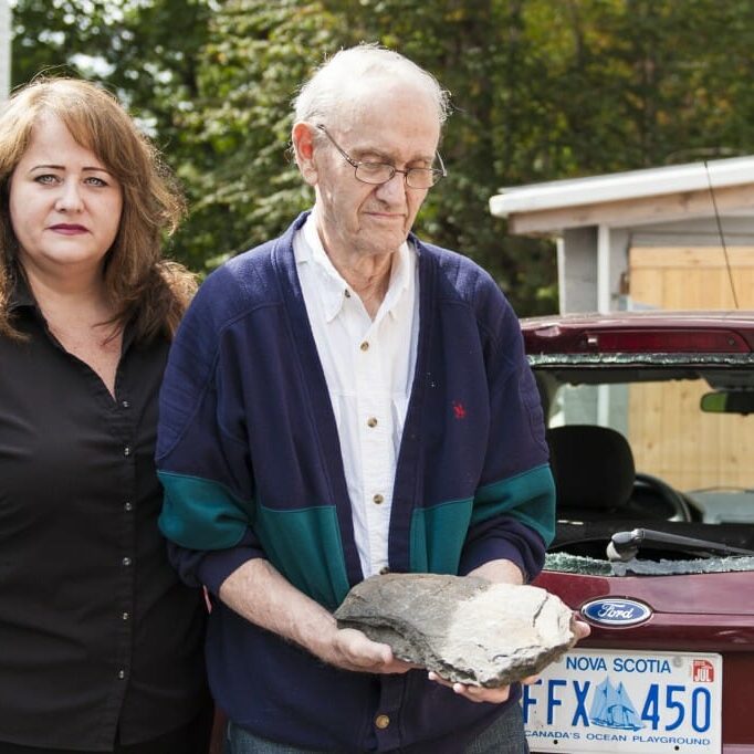 Susan Cotie and her father Daniel with a rock used to damage the 93-year-old's new car.