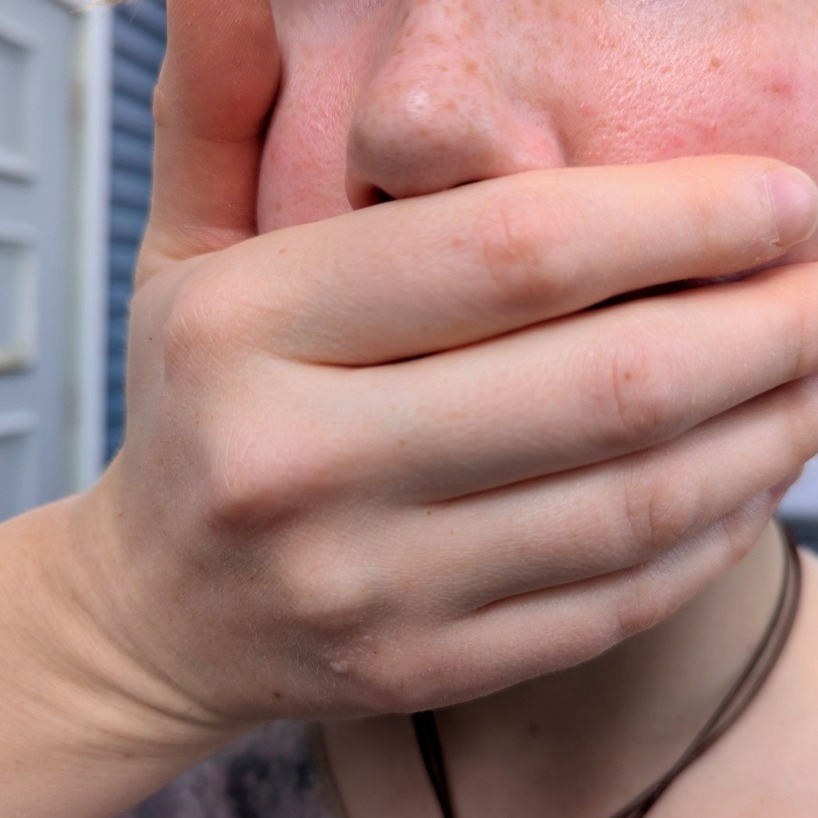 A hand covers a person’s mouth in Halifax Nova Scotia, on Wednesday, Sept. 24, 2025. (Rachel Bass/Dal Gazette)