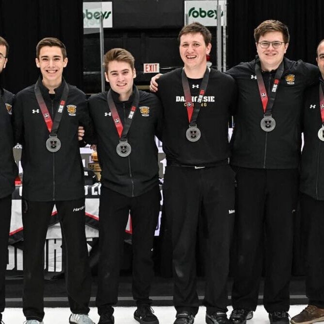The men’s team stands with their silver medals following their loss to the University of Regina. Image credit: Rob Blanchard with Curling Canada