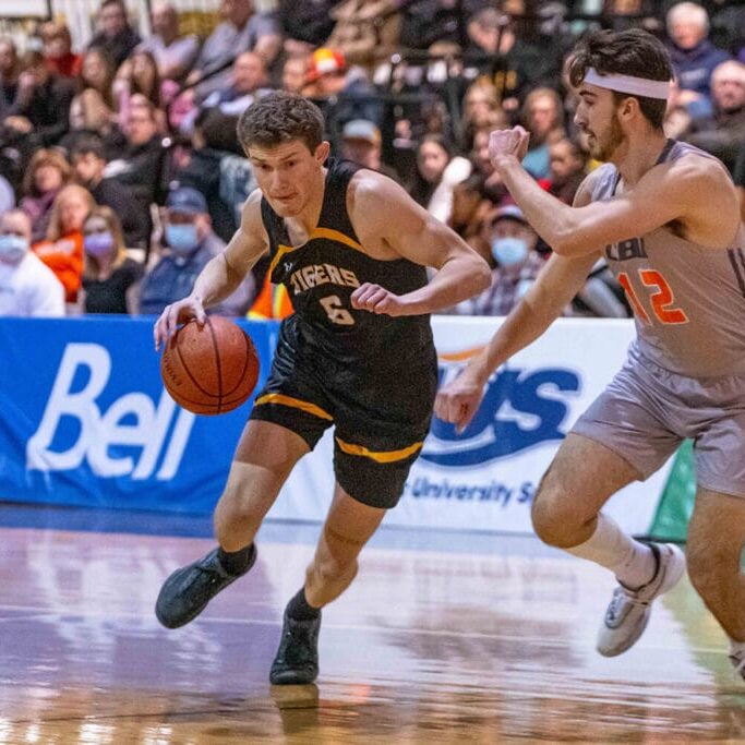 Malcolm Christie fending off a Cape Breton University player in a game last season. Image credit: Dal Tigers photo gallery