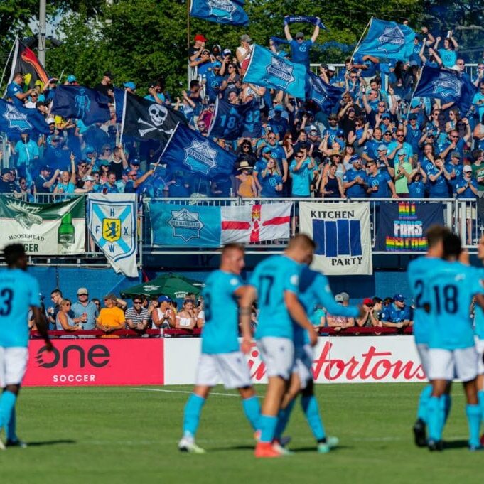 In this image: The crowd cheers for the Halifax Wanderers team at a game.