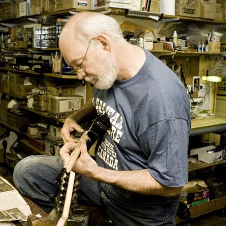Tom Dorward, founder of the Halifax Folklore Centre, strums a guitar at the Brunswick Street music shop. Image via Halifax Folklore Centre.