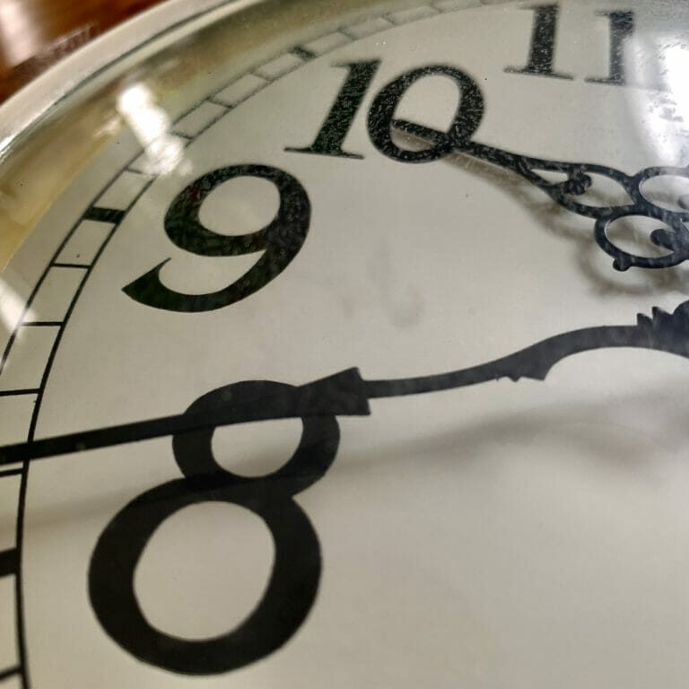 In this image: A clock with its hands on 10 and 8.