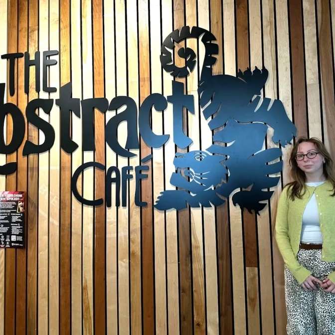 Liv Brennan stands outside the Abstract Café on Dalhousie campus in Halifax, Nova Scotia on March 30, 2026. Brennan is the floor supervisor and co-ordinator for the Café. (Claire Kelly/The Dalhousie Gazette)