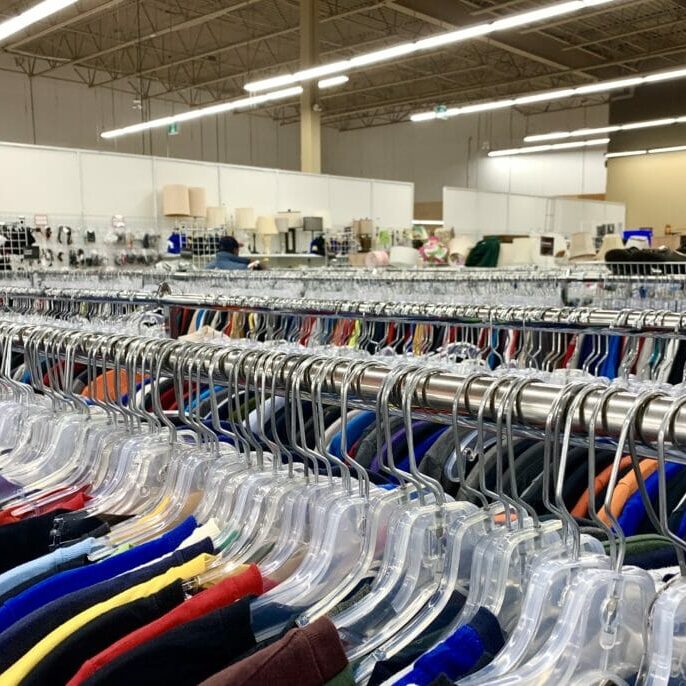 In this image: Racks of clothes at a thrift store.
